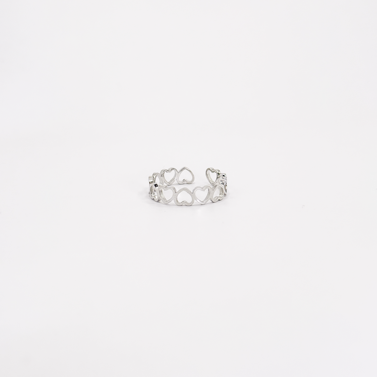 Anillo plateado de acero inoxidable con diseño calado de corazones