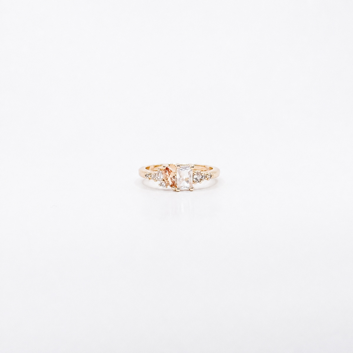 Anillo dorado de chapa de oro con zirconia rectangular, zirconia ovalada y detalles laterales