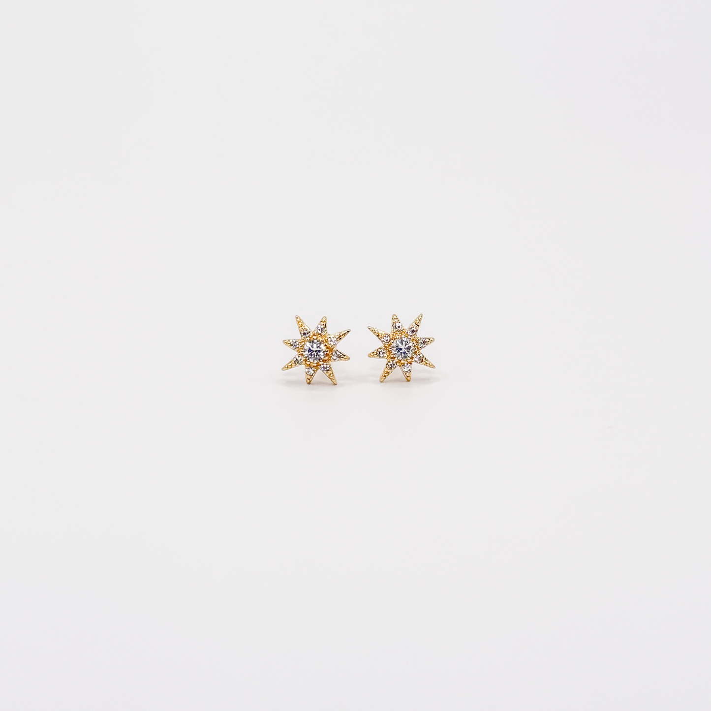 Broqueles dorados con diseño de Estrella del Norte y zirconias