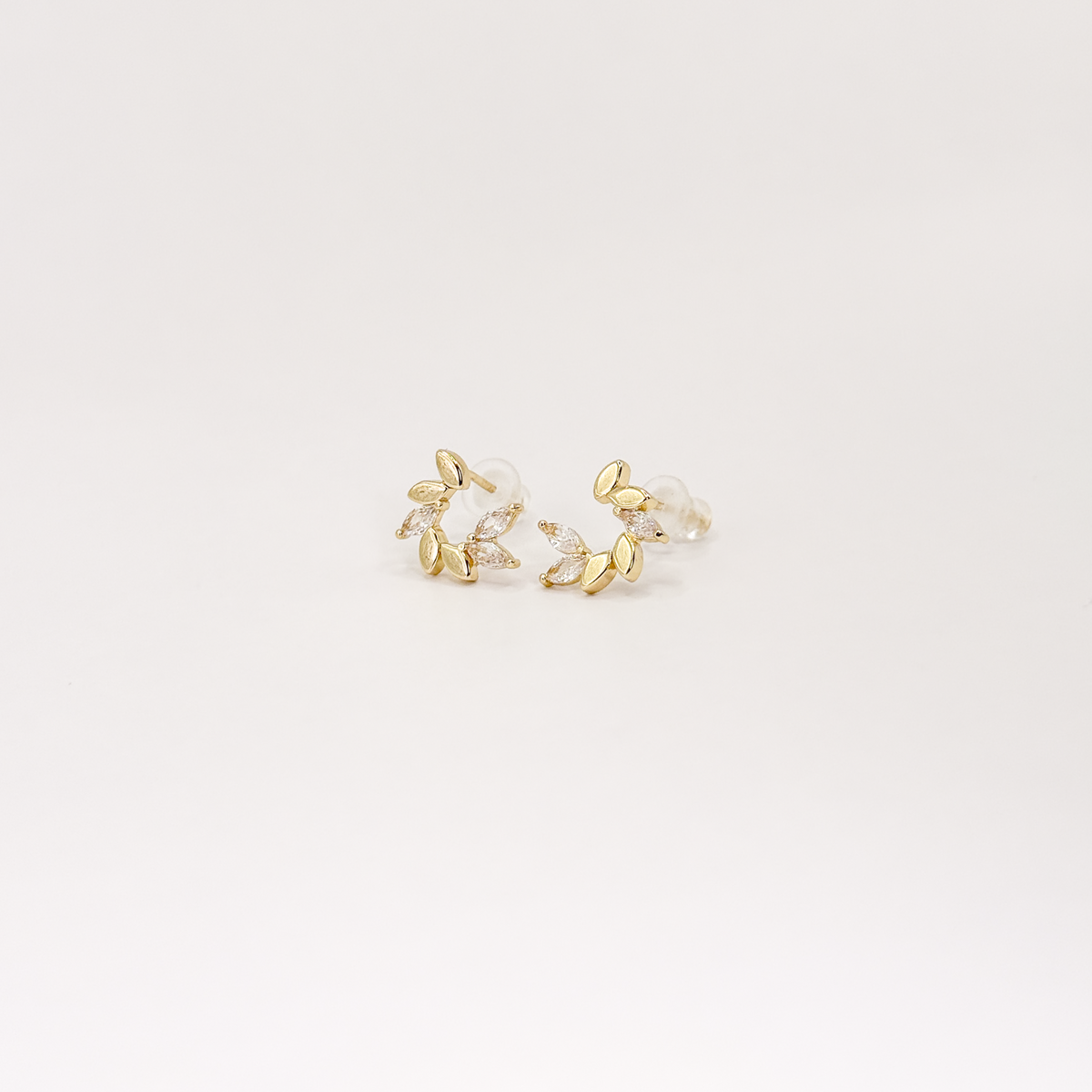 Broqueles dorados con diseño de hojas y zirconias