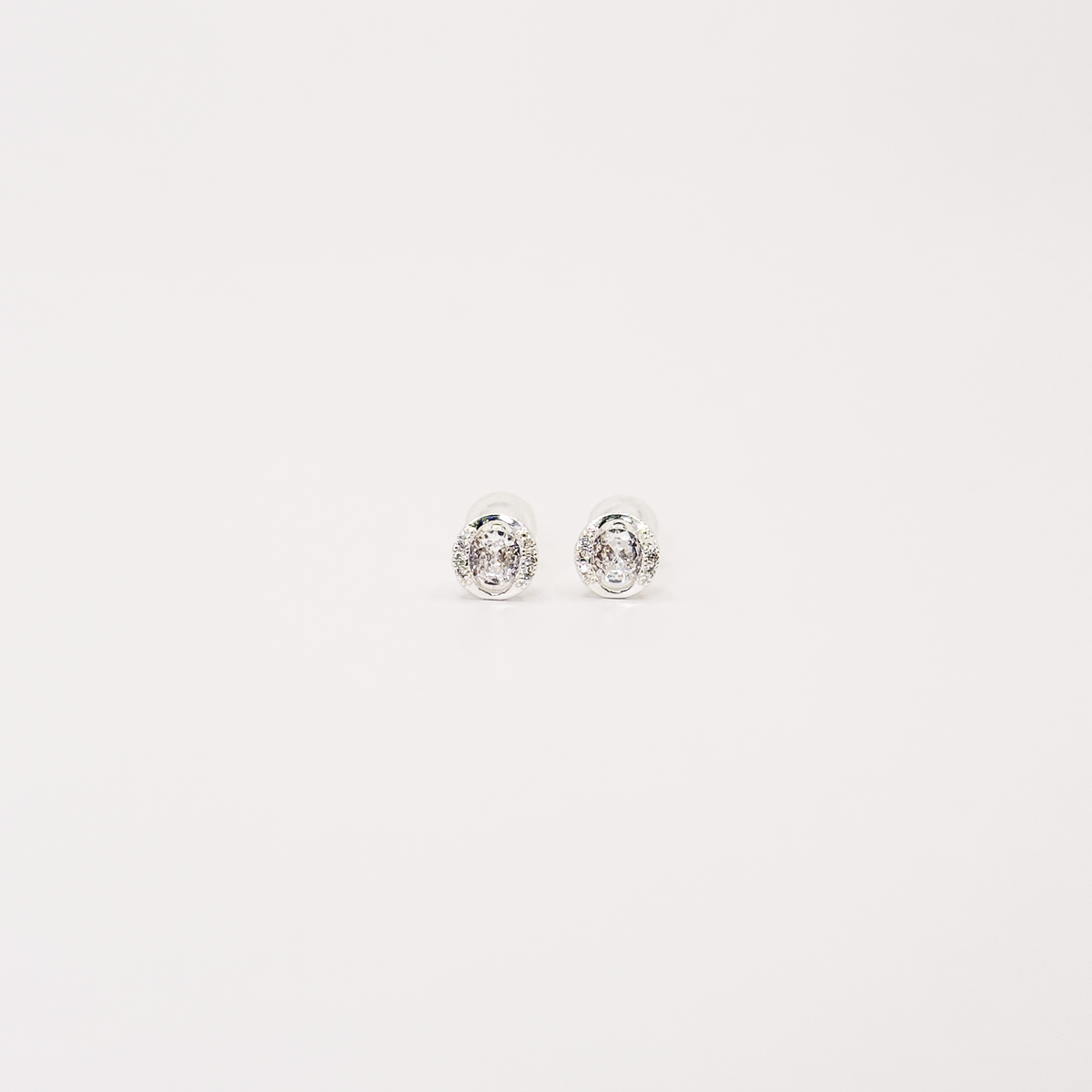 Broqueles mini plateados con zirconia ovalada y contorno brillante