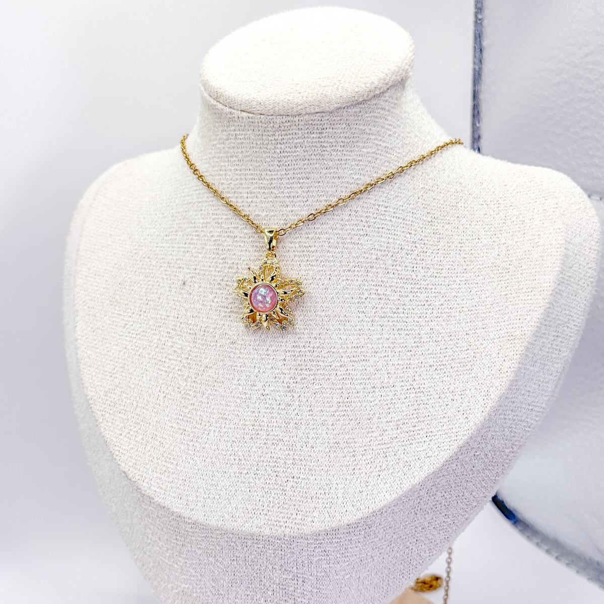 Collar dorado inspirado en Enredados, con dije de sol, centro rosa giratorio y zirconias