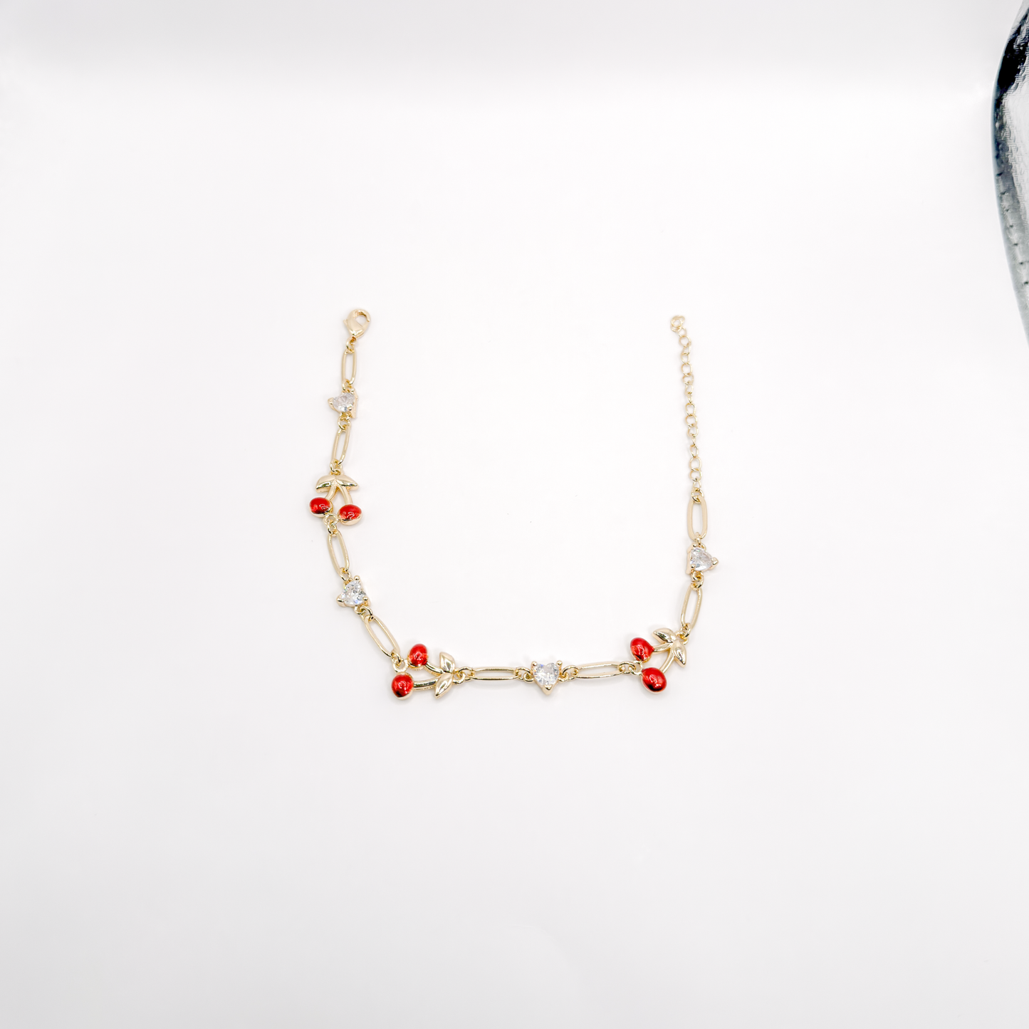 Pulsera dorada con cerezas rojas esmaltadas y zirconias en forma de corazón