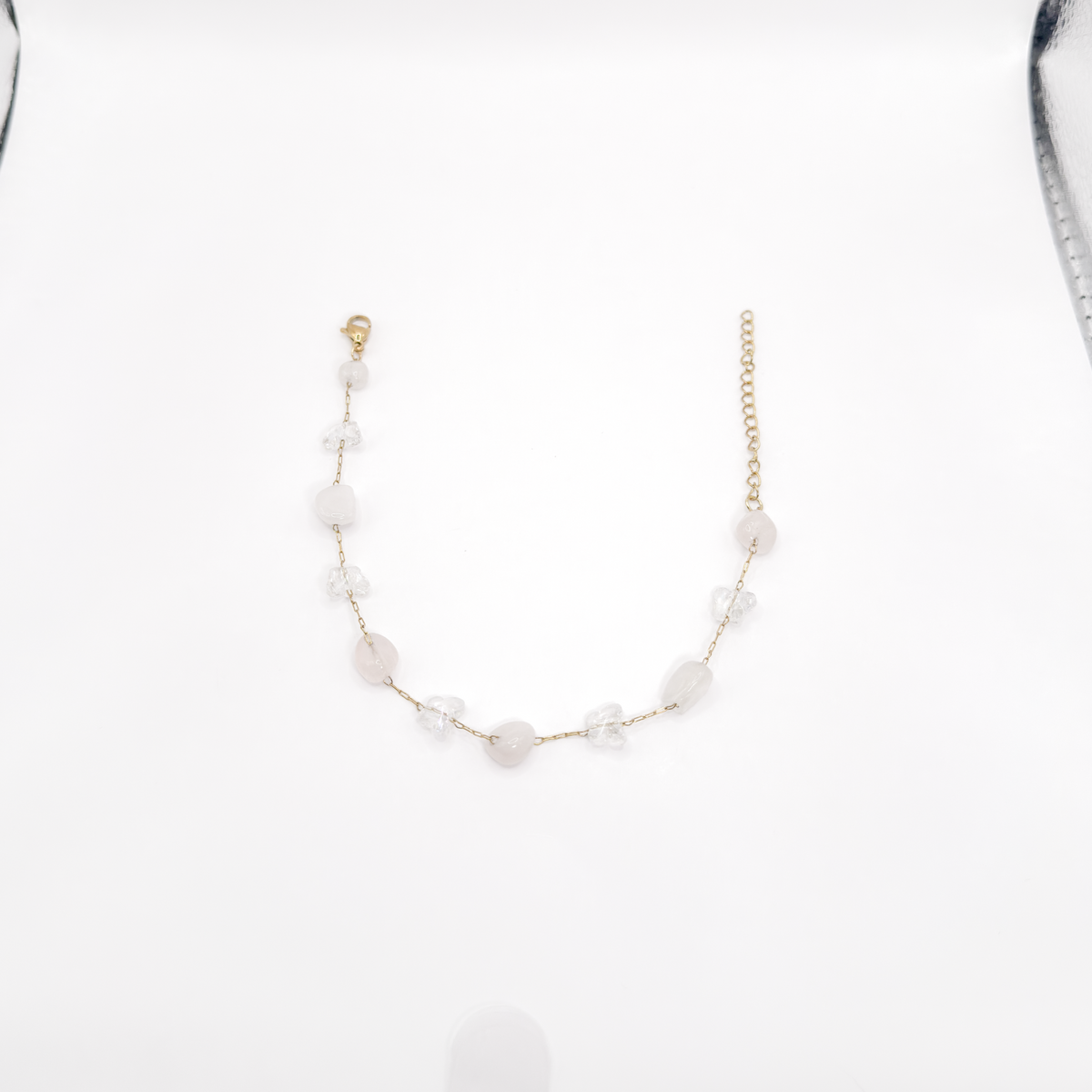 Pulsera dorada con mariposas transparentes y piedras irregulares en tono rosa claro