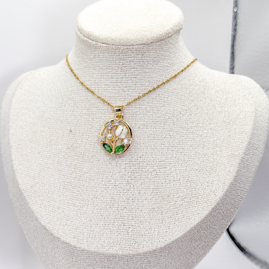 Collar dorado con dije circular de tulipanes blancos, hojas verdes, perla y zirconias