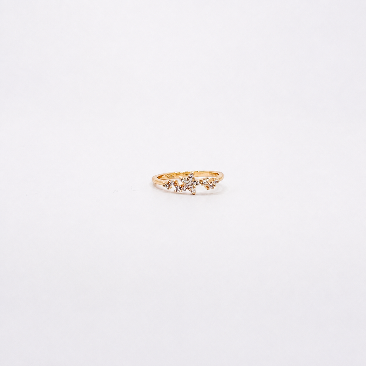 Anillo dorado de chapa de oro con estrella central y detalles de zirconias