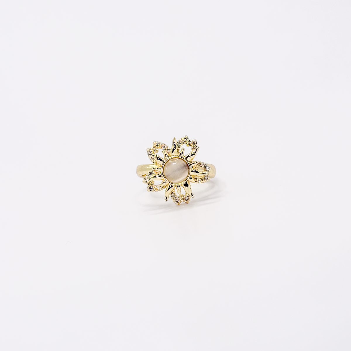 Anillo dorado de chapa de oro con diseño de sol, zirconias y centro giratorio