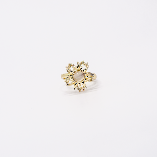 Anillo dorado de chapa de oro con diseño de sol, zirconias y centro giratorio