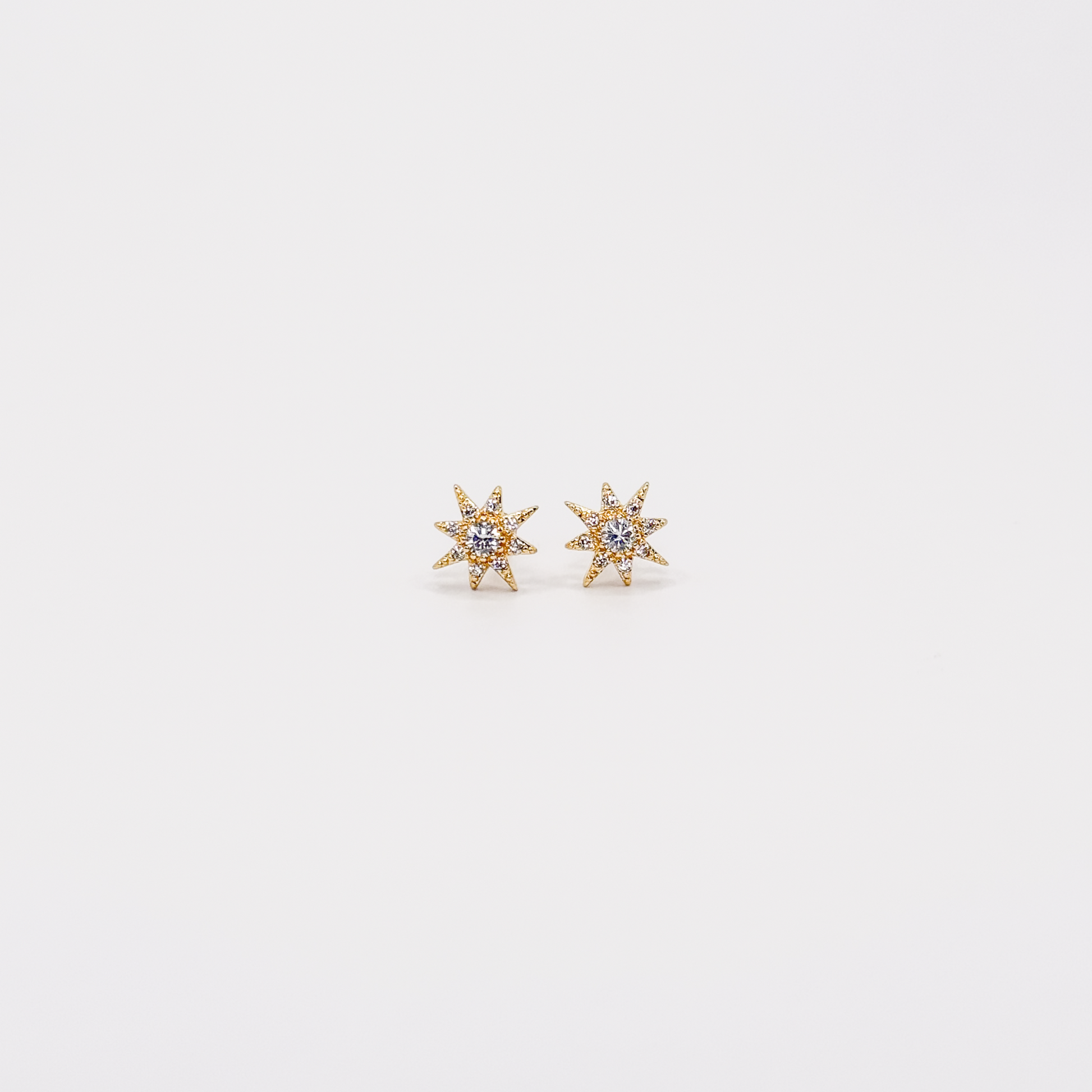 Broqueles dorados con diseño de Estrella del Norte y zirconias