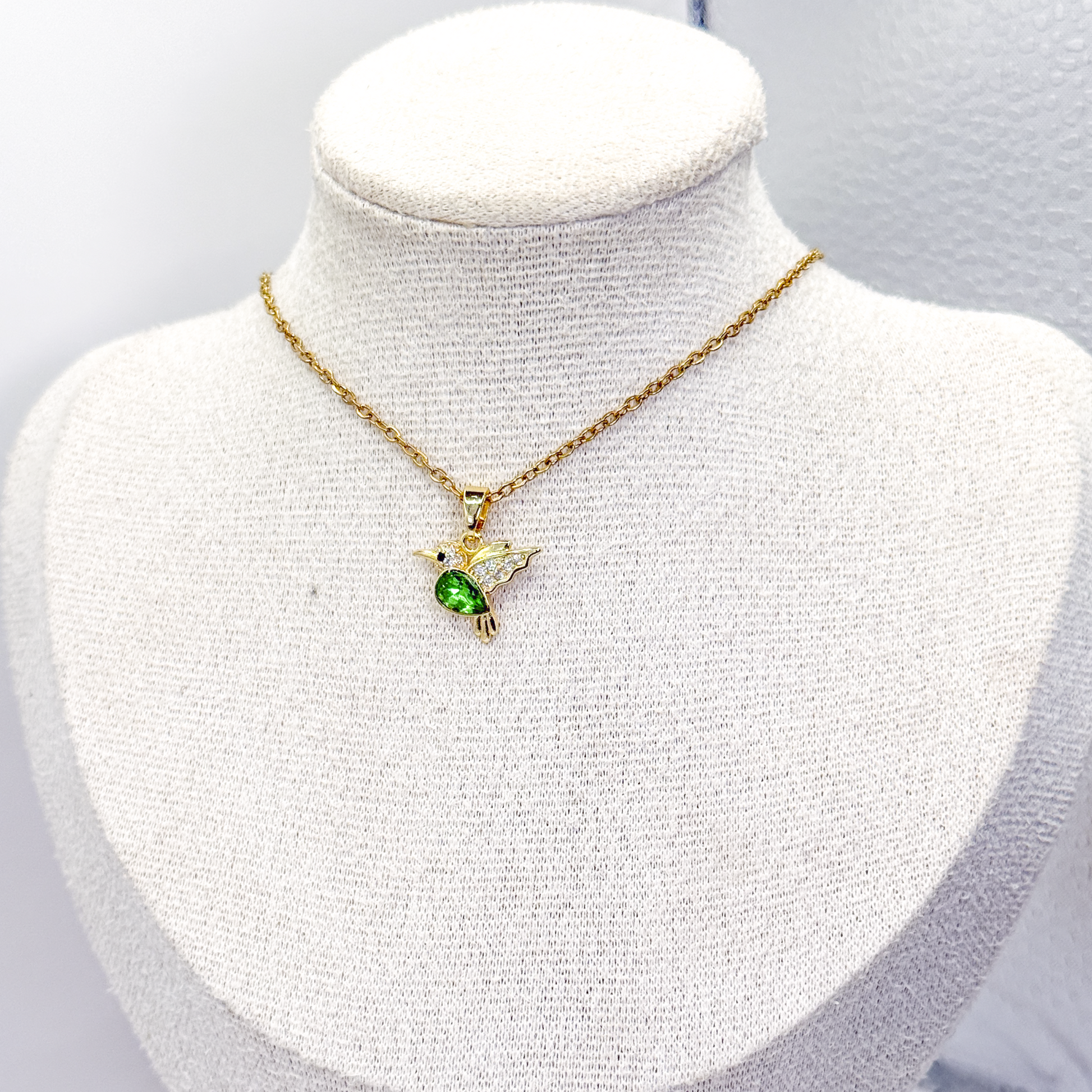 Collar dorado con dije de colibrí, zirconia verde y zirconias en las alas