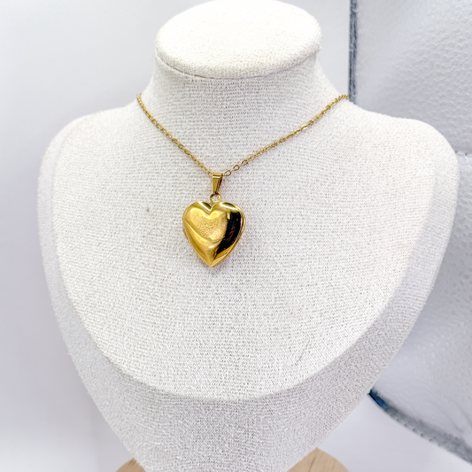 Collar dorado con relicario liso en forma de corazón