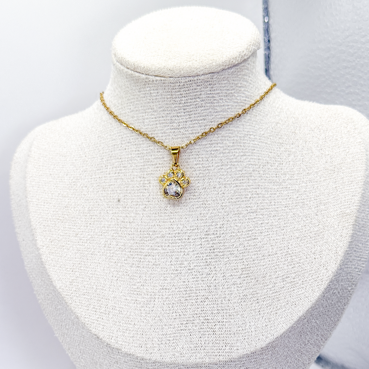 Collar dorado con dije de huella y zirconias