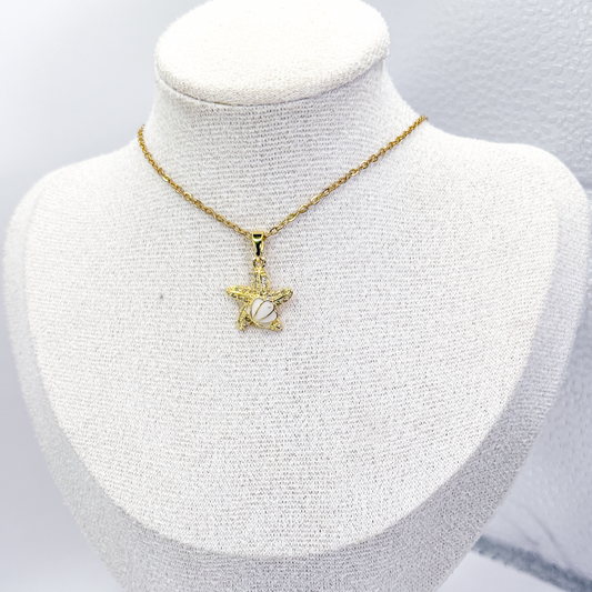 Collar dorado con dije de estrella de mar, concha blanca y zirconias