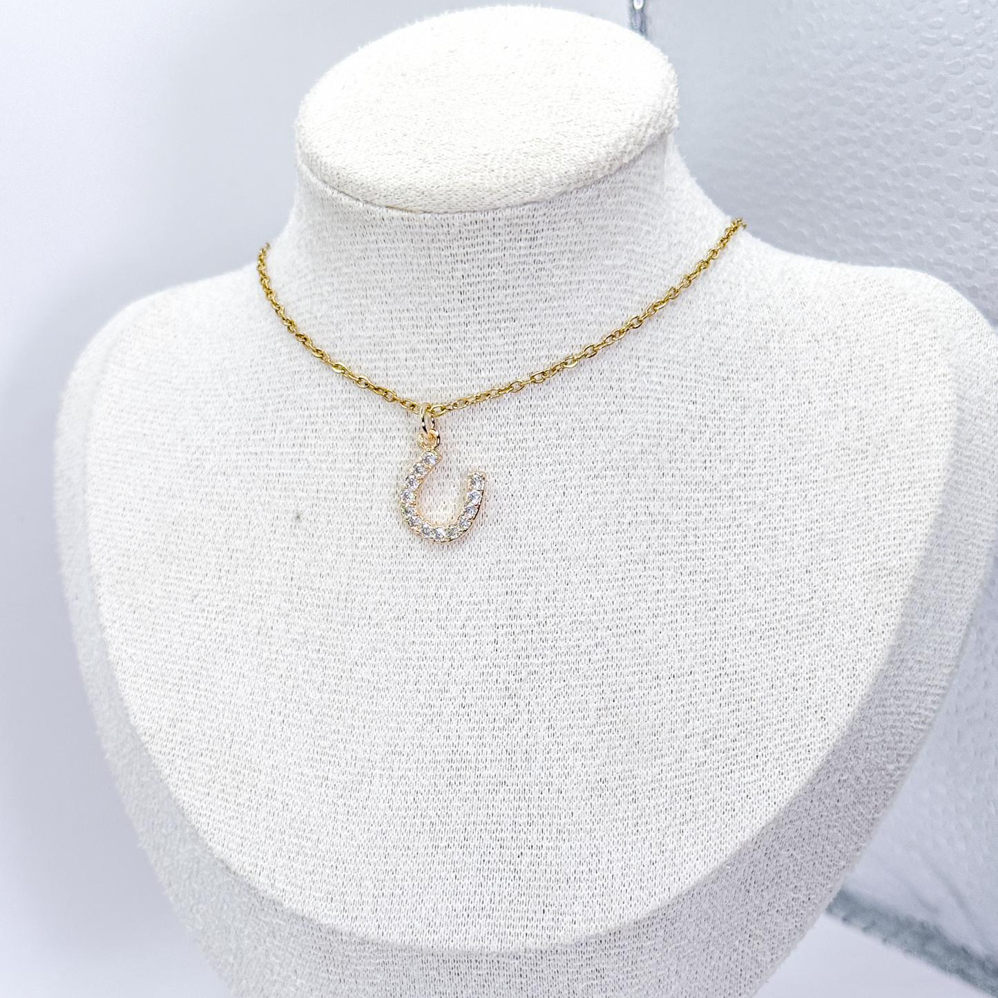 Collar dorado con dije de herradura decorado con zirconias