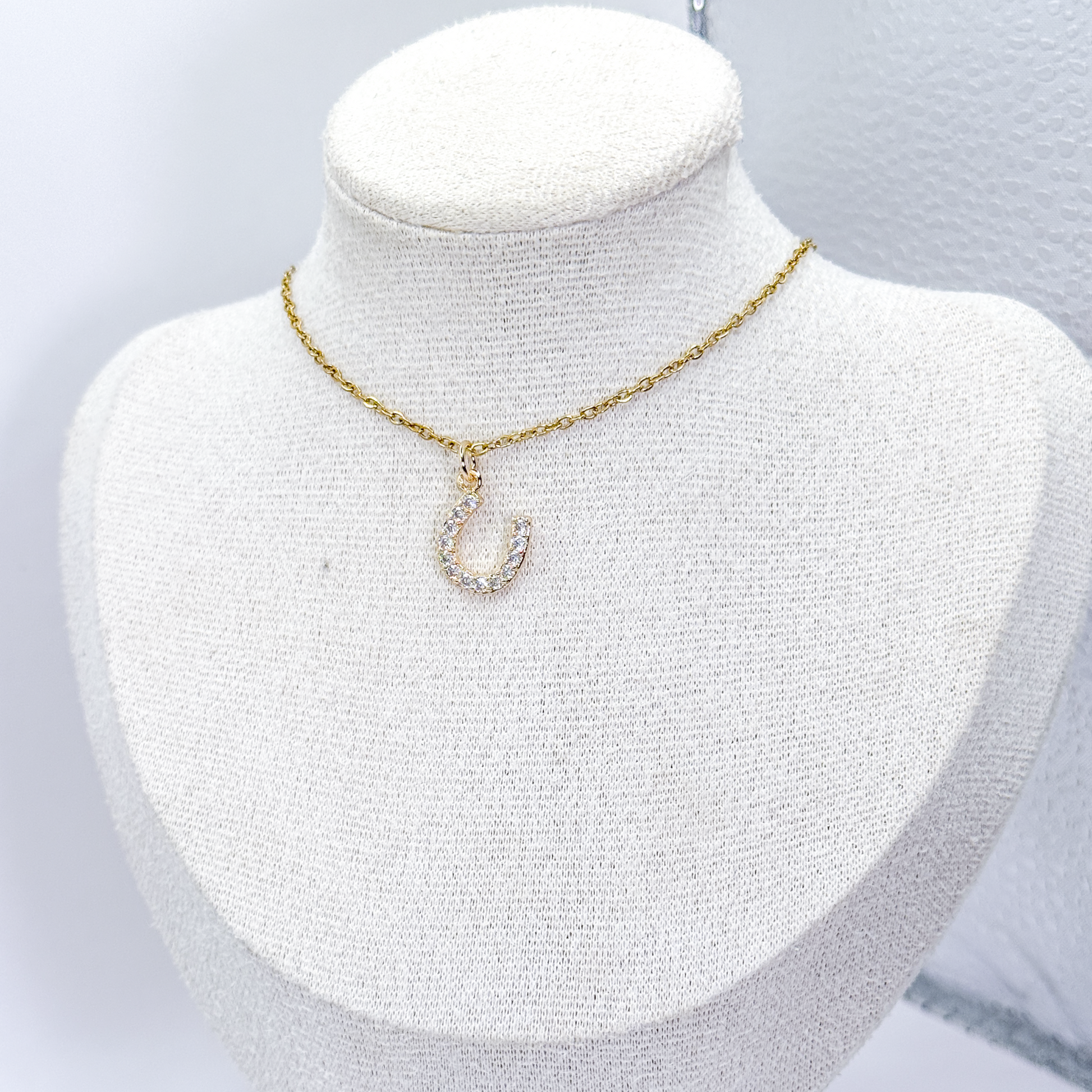 Collar dorado con dije de herradura decorado con zirconias