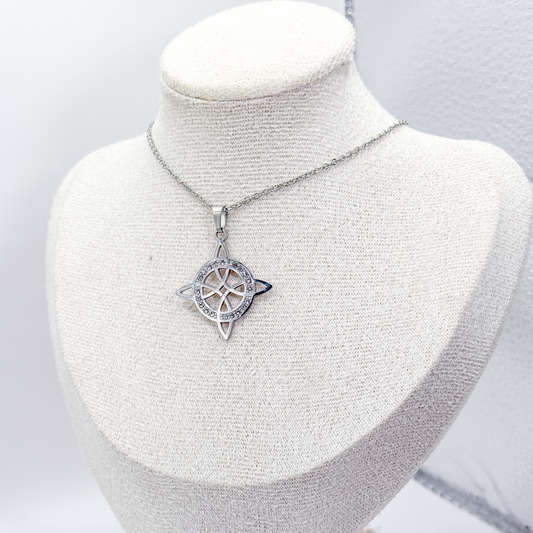 Collar plateado con dije de nudo de bruja decorado con zirconias