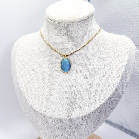 Collar dorado con dije ovalado de piedra ojo de gato azul