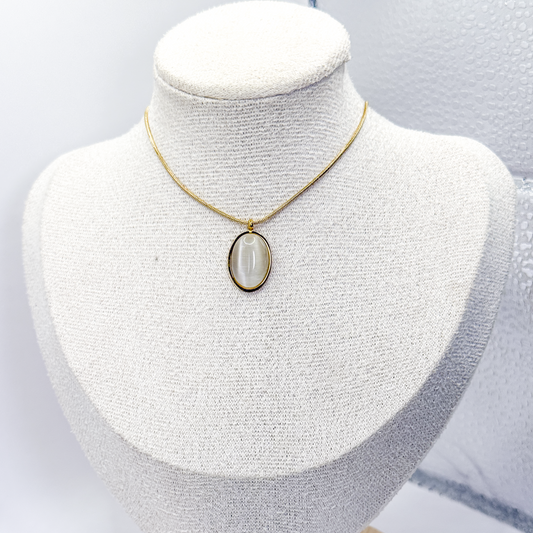 Collar dorado con dije ovalado de piedra ojo de gato blanca