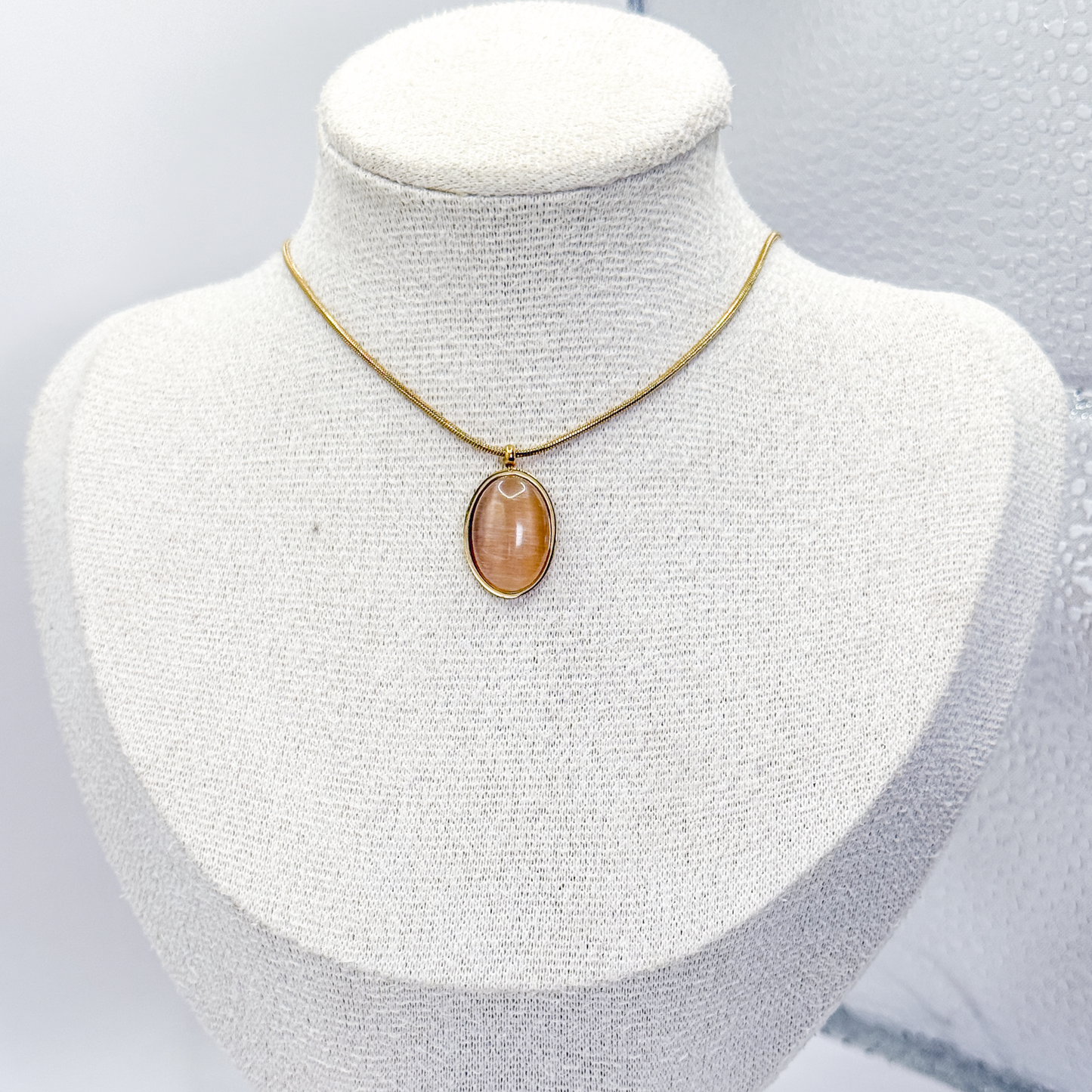 Collar dorado con dije ovalado de piedra ojo de gato café