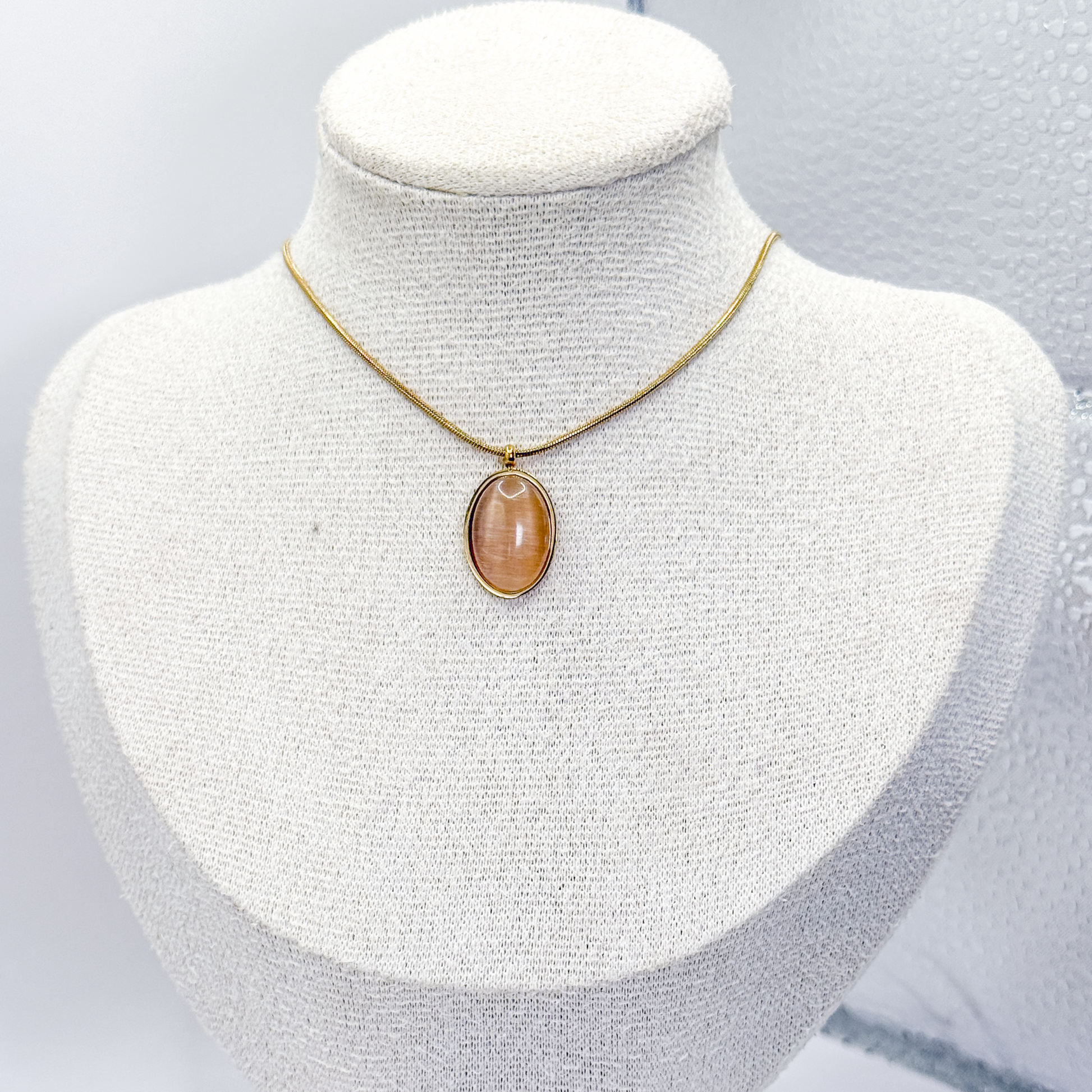 Collar dorado con dije ovalado de piedra ojo de gato café