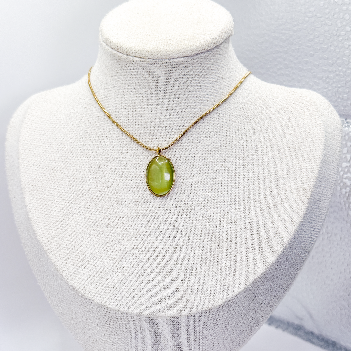 Collar dorado con dije ovalado de piedra ojo de gato verde