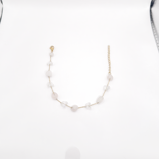 Pulsera dorada con mariposas transparentes y piedras irregulares en tono rosa claro